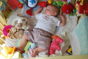 bebé dormido con juguetes y peluches